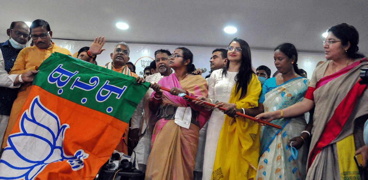 Trinamool Congress MLA Sonali Guha (4R), Tollywood actress Tanusree Chakraborty (3R) and TMC leader Sarala Mormu (2R) receive the BJP party flag from state BJP President Dilip Ghosh, BJP National Vice President Mukul Roy and party MP Locket Chatterjee, during an event to mark their joining of BJP, in Kolkata. Credit: PTI Photo