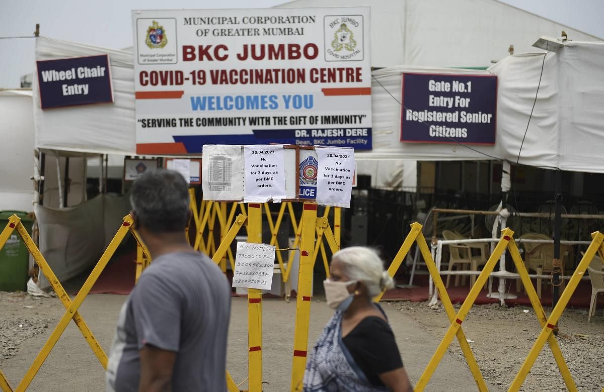 People read a notice that states 'No vaccination for 3 days as per BMC (Brihanmumbai Municipal Corporation) orders' pasted outside a coronavirus vaccination centre in Mumbai, Friday, April 30, 2021. Credit: PTI Photo