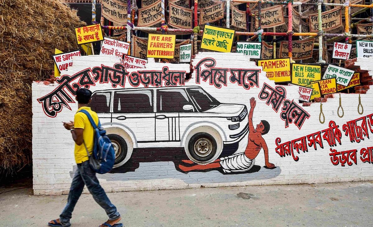 A man walks past a pandal depicting the plight of farmers in the country and their ongoing agitation, ahead of Durga Puja Festival in Kolkata. Credit: PTI Photo
