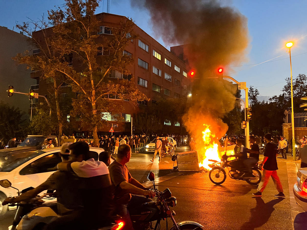 Demonstrators gather around a burning barricade during a protest for Mahsa Amini. Credit: AFP Photo