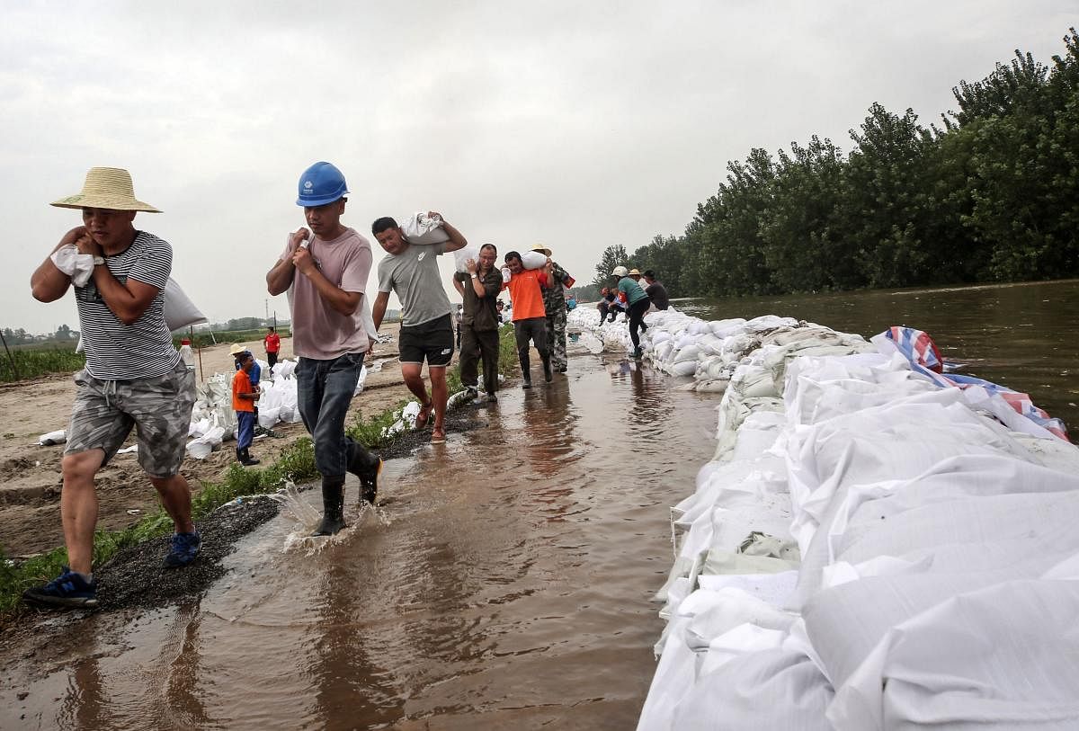 China rushes to contain floods after record rainfall