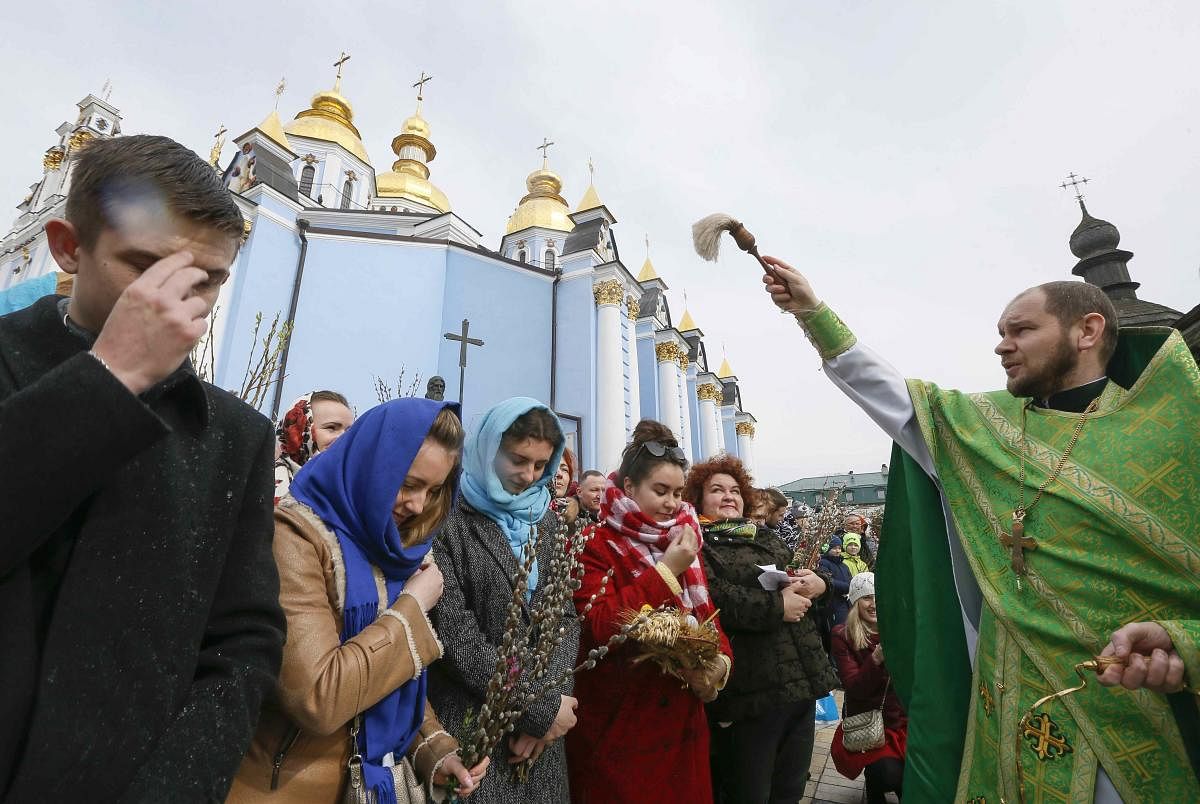 An Orthodox priest sprays holy water as believers mark the Palm Sunday outside the St. Michael's Golden-Domed Cathedral in Kiev, Ukraine. Reuters Photo