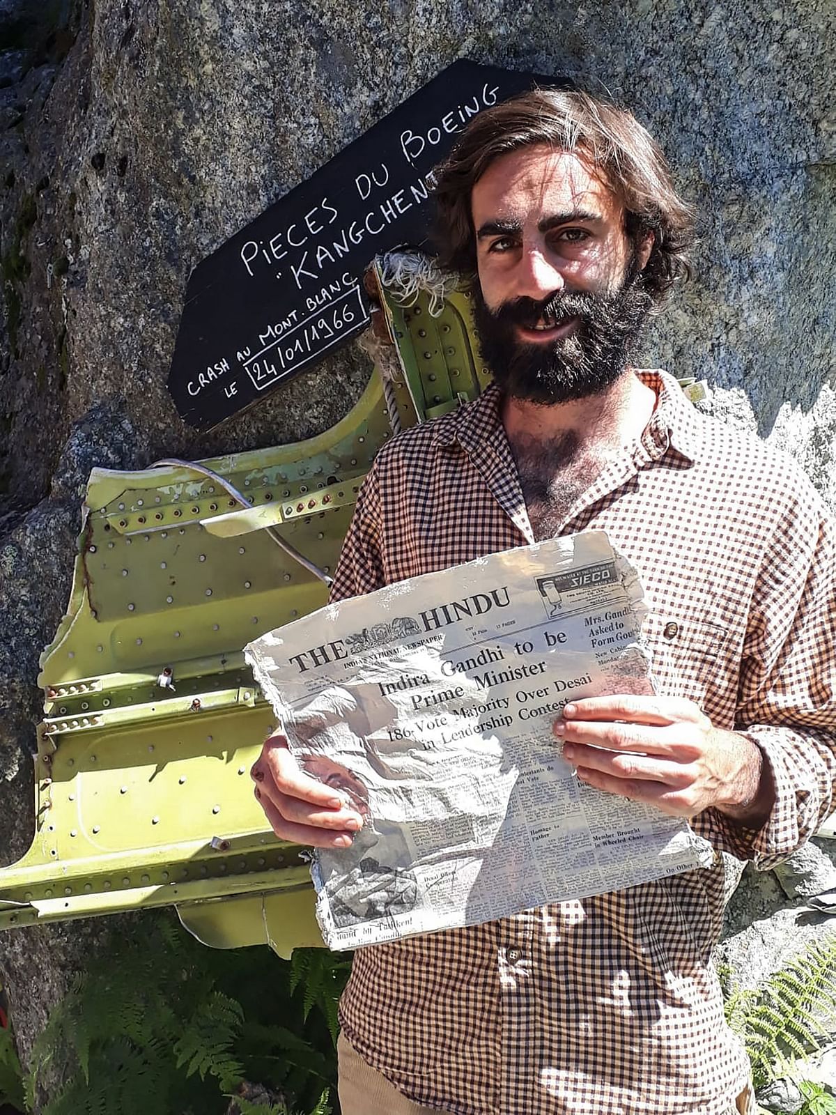 Thimotee Mottin, manager of the cafe-restaurant Cabane du Cerro near the Bossons glacier, poses on July 9, 2020, at his cafe near Chamonix in the French Alps, holding a 1966 copy of Indian newspaper The Hindu, likely to have been on board the Air India Boeing 707