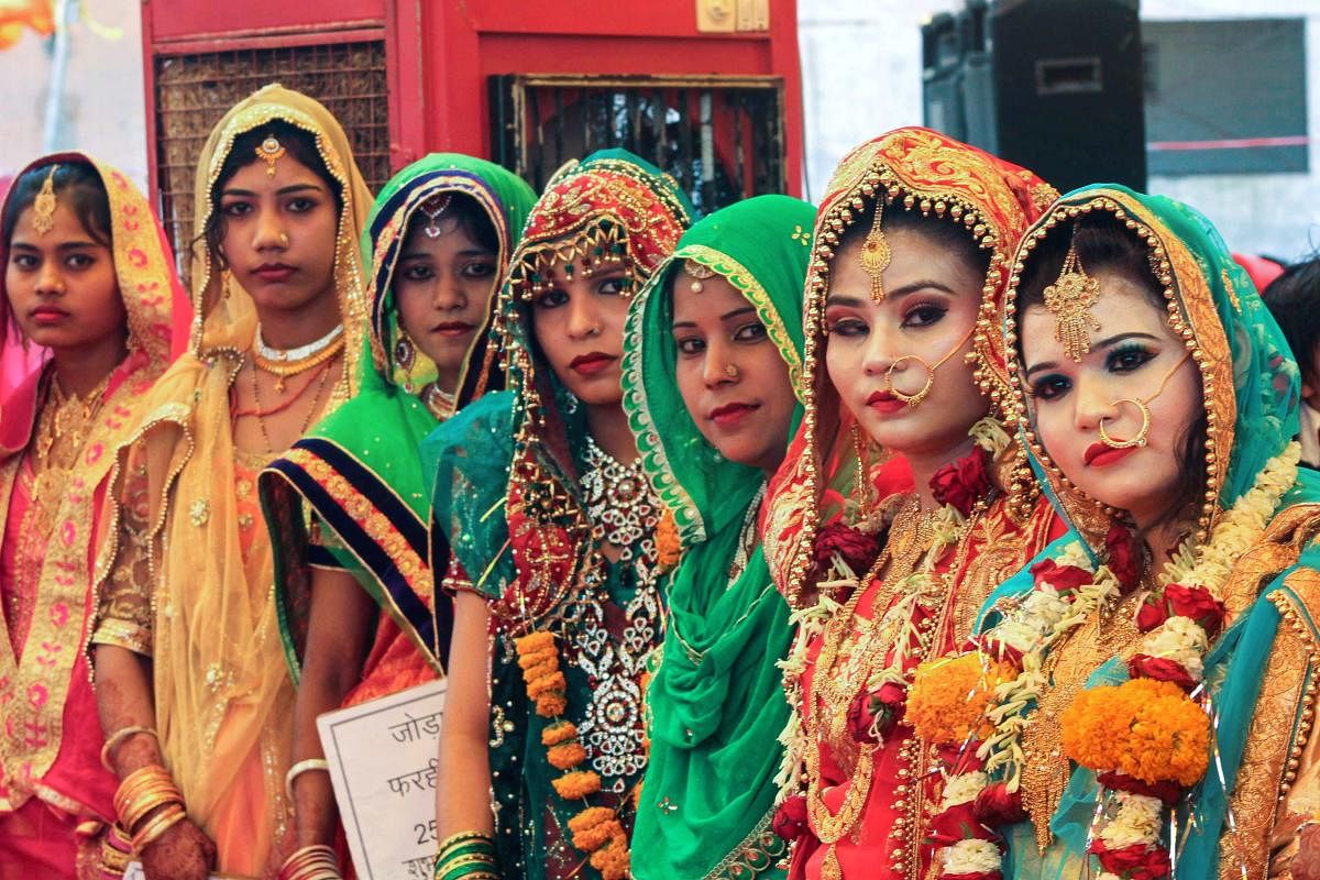 Brides pose for a photograph during a mass marriage ceremony under Mukhyamanti Kanyadan Yojna in Bhopal on Wednesday. More than 65 couples tied the knot. PTI Photo