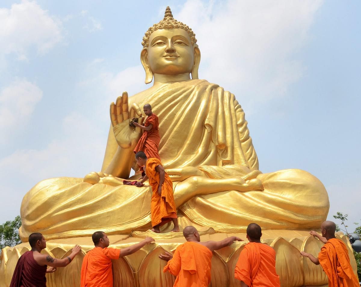 Buddhists monks clean a statue of Lord Buddha ahead of Buddha Purnima festival in Howrah on Wednesday. PTI Photo