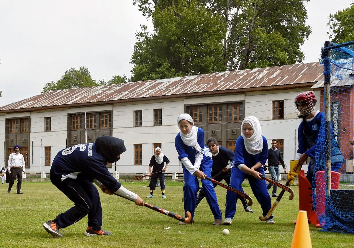 Students in action during an inaugural match of 5-a-side women's hockey tournament as it was re-introduced after two decades at Women's College in Srinagar on Wednesday. PTI Photo