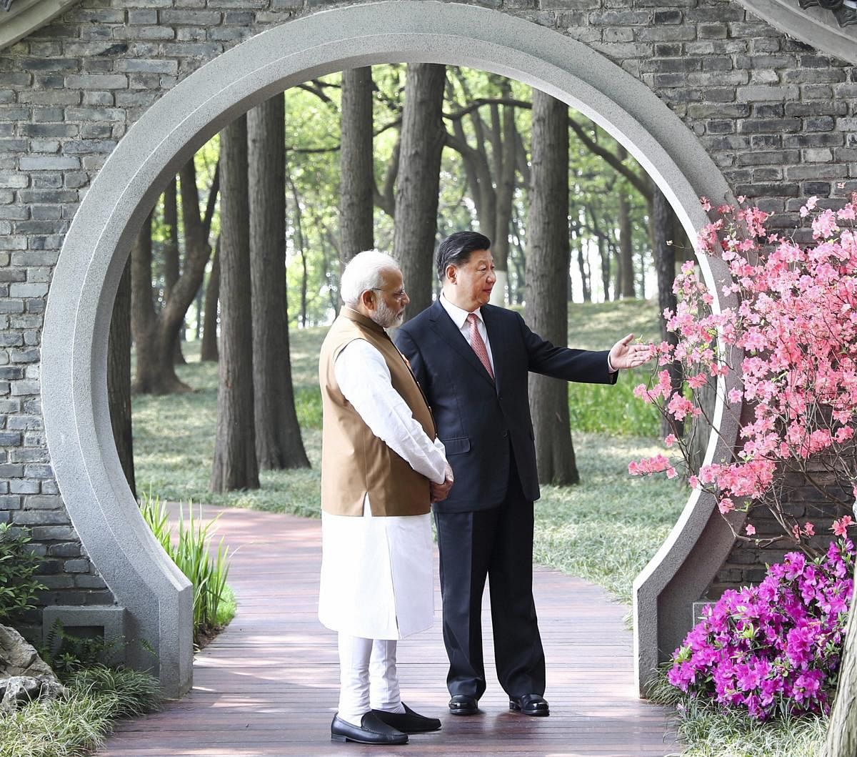 In this photo released by China's Xinhua News Agency, Indian Prime Minister Narendra Modi, left, and Chinese President Xi Jinping talk at a garden in Wuhan in central China's Hubei Province, Saturday, April 28, 2018. The leaders of China and India stressed the importance of close ties in talks Saturday, against the background of their rivalry for leadership in Asia and the potential for cooperation on economic and security matters. (AP/PTI)
