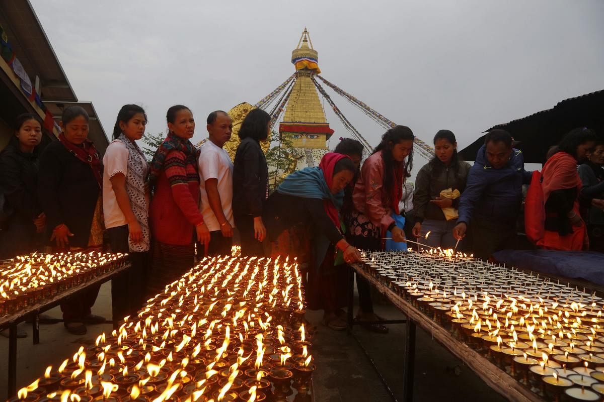 Nepalese Buddhist devotees line up in a queue to light butter lamps in a monastery during Buddha Jayanti or Buddha Purnima in Boudhanath stupa, Kathmandu, Nepal. AP/PTI Photo