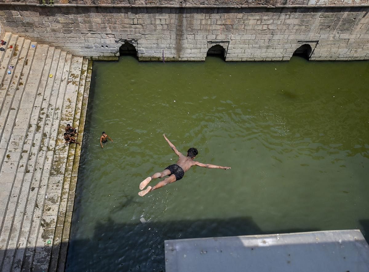 A young boy dives into the water at Nizamuddin Baoli on a hot, summer day in New Delhi on Monday. PTI Photo