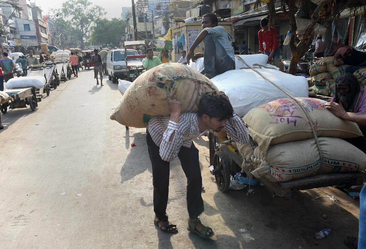A worker carries sacks at the Khari Baoli wholesale market in New Delhi on International Labour Day, also known as May Day, on Tuesday. PTI Photo