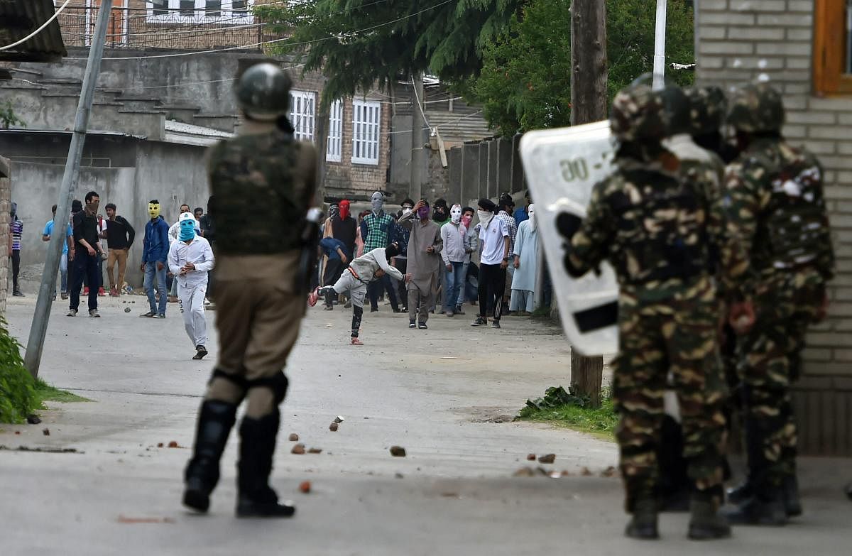 Protesters throw stones on security personnel during a clash in Srinagar on Tuesday. PTI Photo