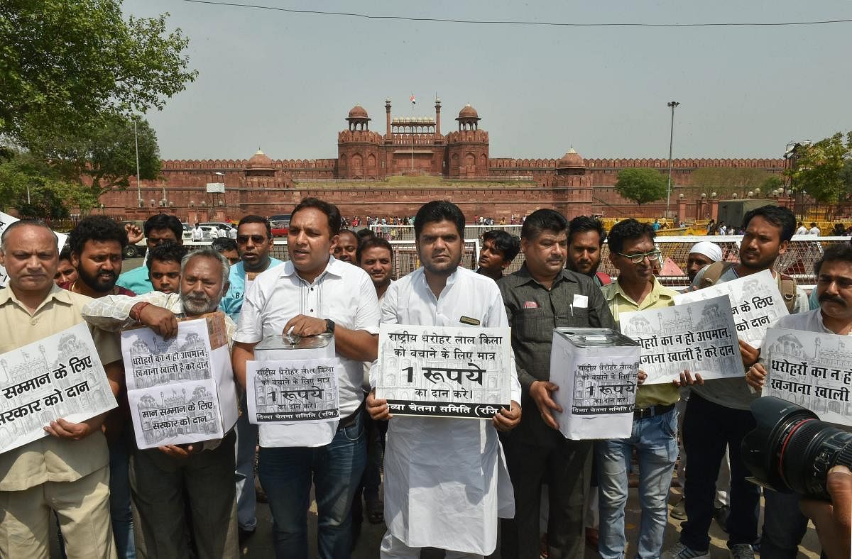 Members of Divya Chetna Samiti display placards at a protest to save Red Fort in the view of the recently signed MoU between Dalmia Bharat and Ministry of Culture for upkeeping the historic monument, in New Delhi on Wednesday. PTI Photo