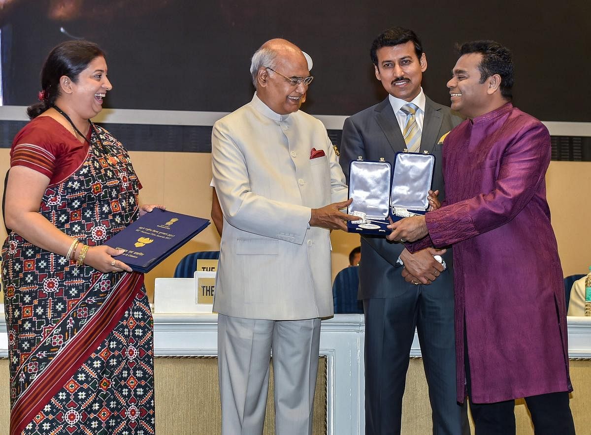 President Ram Nath Kovind confers Best Music Direction Award on AR Rahman during the 65th National Film Awards function at Vigyan Bhavan in New Delhi on Thursday. I & B Minister Smriti Irani and MoS for I & B Rajyavardhan Rathore are also seen. PTI Photo