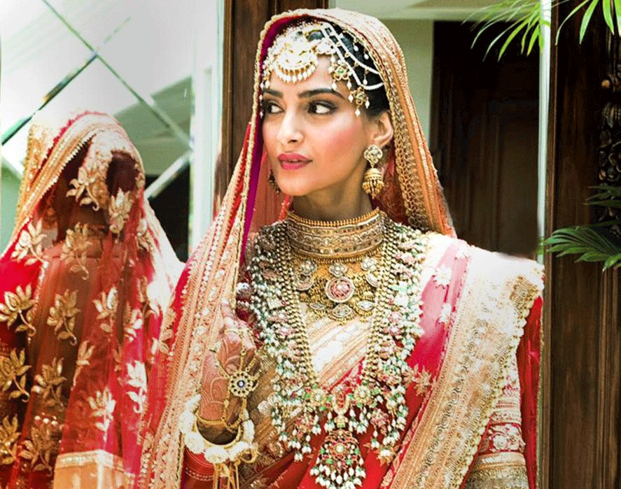 Bollywood actress Sonam Kapoor dressed in a bridal red lehenga poses for a photograph during her wedding in Mumbai on Tuesday. PTI Photo