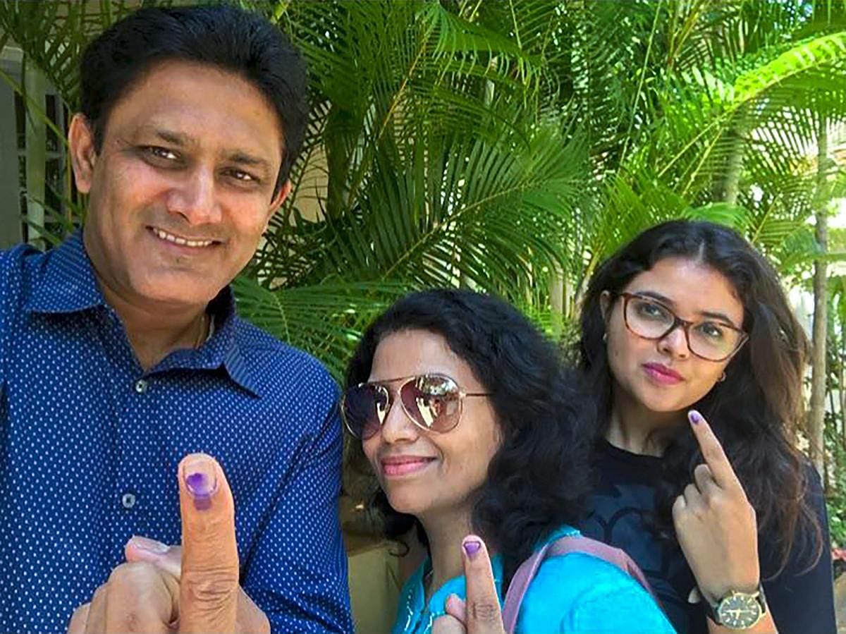 Former cricket captain Anil Kumble, along with his family, shows his finger marked with indelible ink after casting votes for Assembly elections in Bengaluru on Saturday. (PTI Photo / Twitter@anilkumble1074)