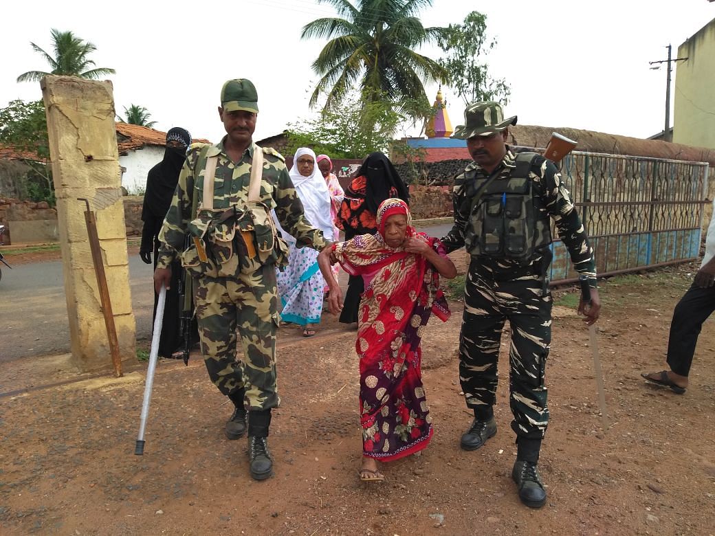 CRPF personnel helping a 90-year-old to the polling booth at Yamakanamaradi ST reserved constituency in Belagavi district. DH Photo