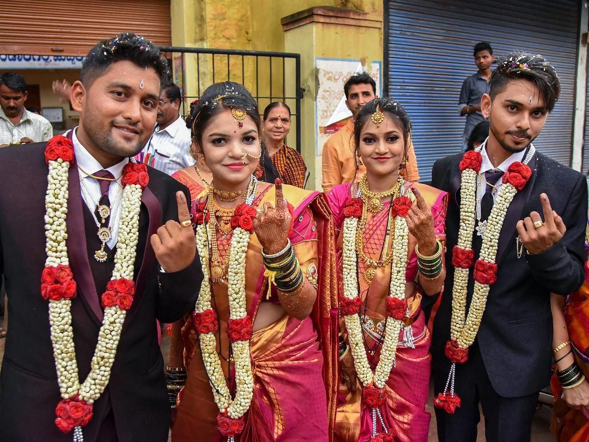 Two newly married couples show their ink-marked fingers after casting their votes for Karnataka Assembly elections in Hubbali on Saturday. PTI Photo