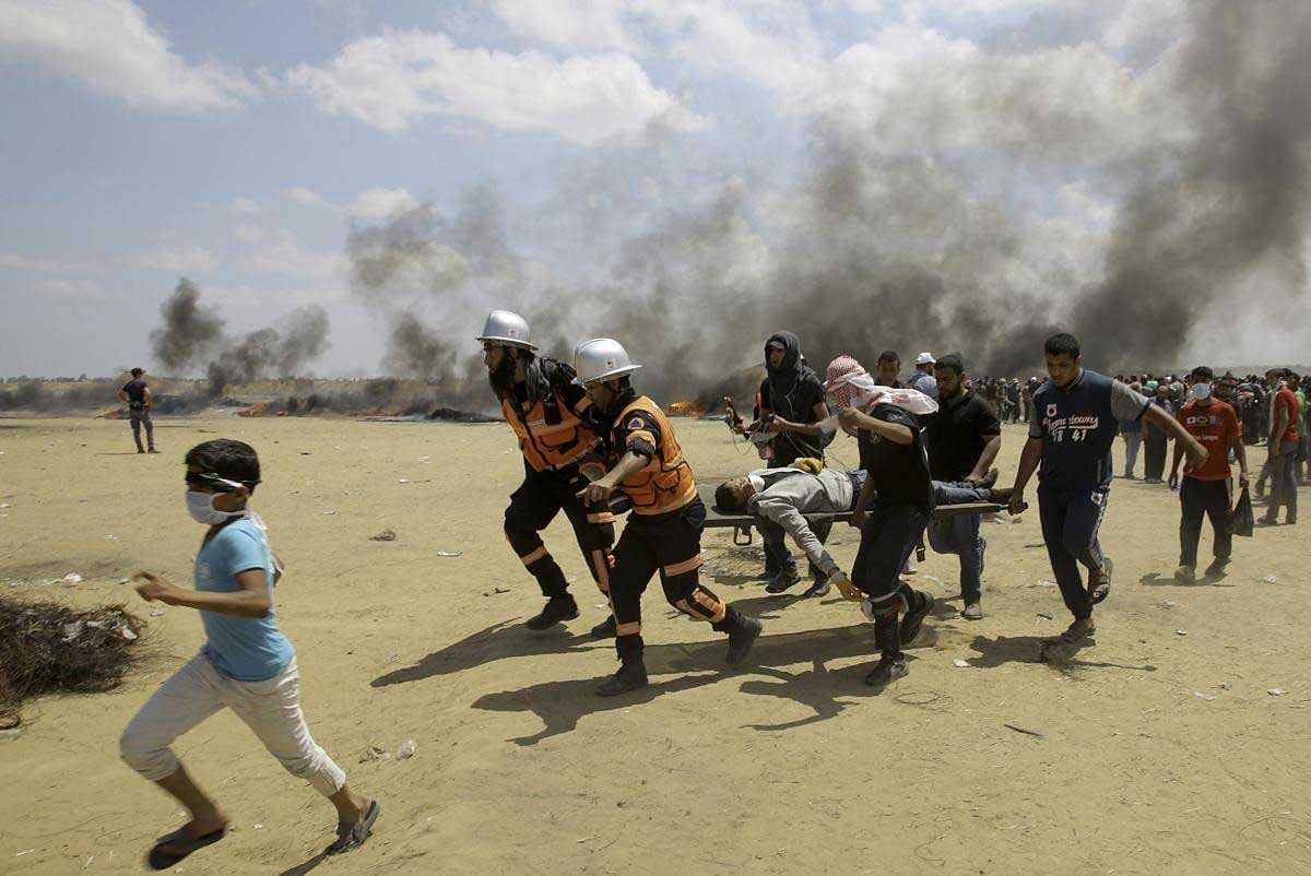 Palestinian medics and protesters evacuate a wounded youth during a protest at the Gaza Strip's border with Israel, east of Khan Younis, Gaza Strip, Monday, May 14, 2018. Thousands of Palestinians are protesting near Gaza's border with Israel, as Israel prepared for the festive inauguration of a new U.S. Embassy in contested Jerusalem. AP/PTI