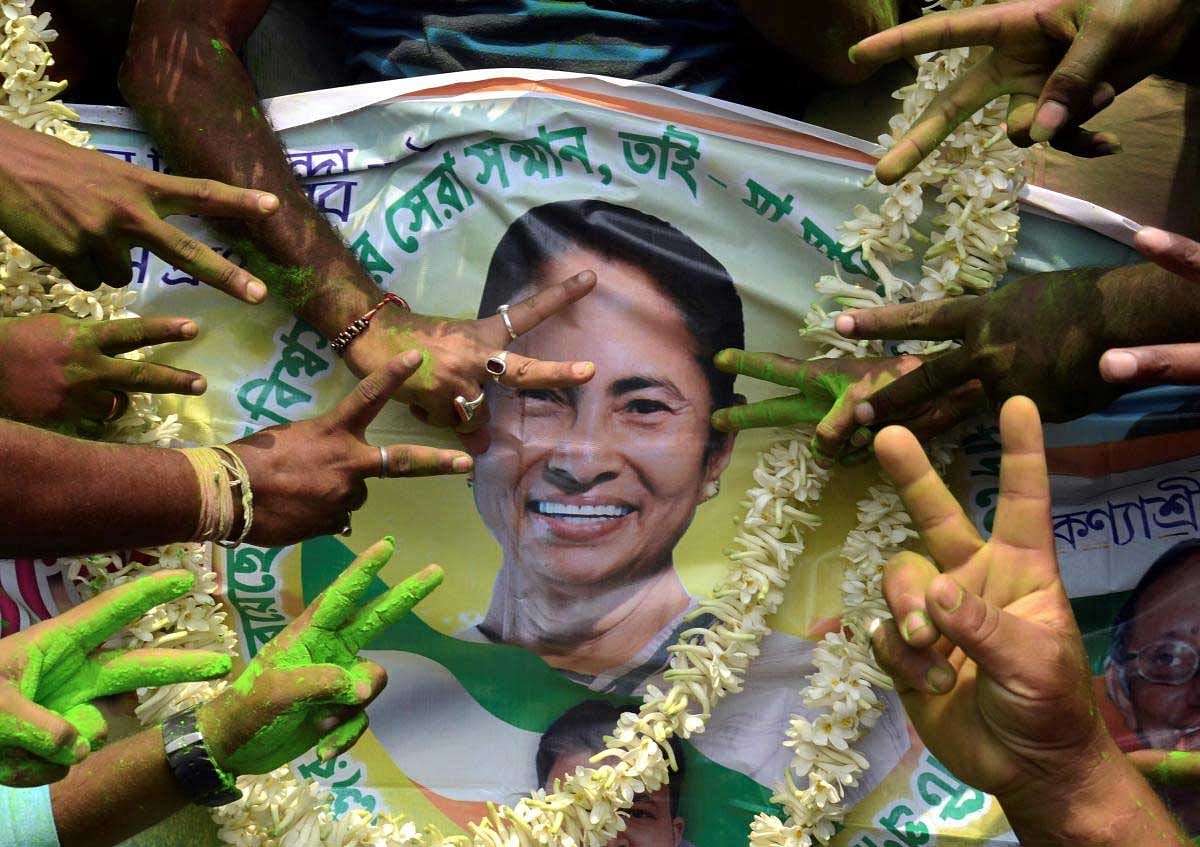 All India Trinamool Congress supporters celebrate with a poster of TMC Chief and West Bengal Chief Minister Mamata Banerjee to celebrate their win in Panchayat elections, in North 24 Parganas, on Thursday. PTI Photo