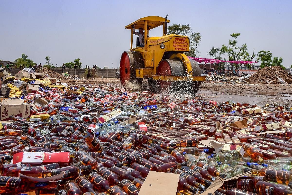 A road roller destroys a stock of illegal liquor at Kamdhenu ground, in Ahmedabad. PTI Photo