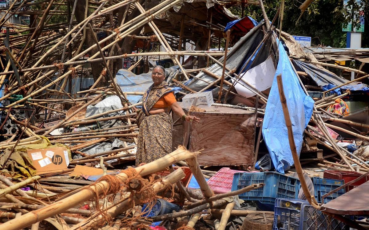 A woman stands among the debris of the temporary shops demolished by Navi Mumbai Municipal Corporation (NMMC) during an anti-encroachment drive against illegal hawkers, at Vashi, in Navi Mumbai, on Thursday. PTI