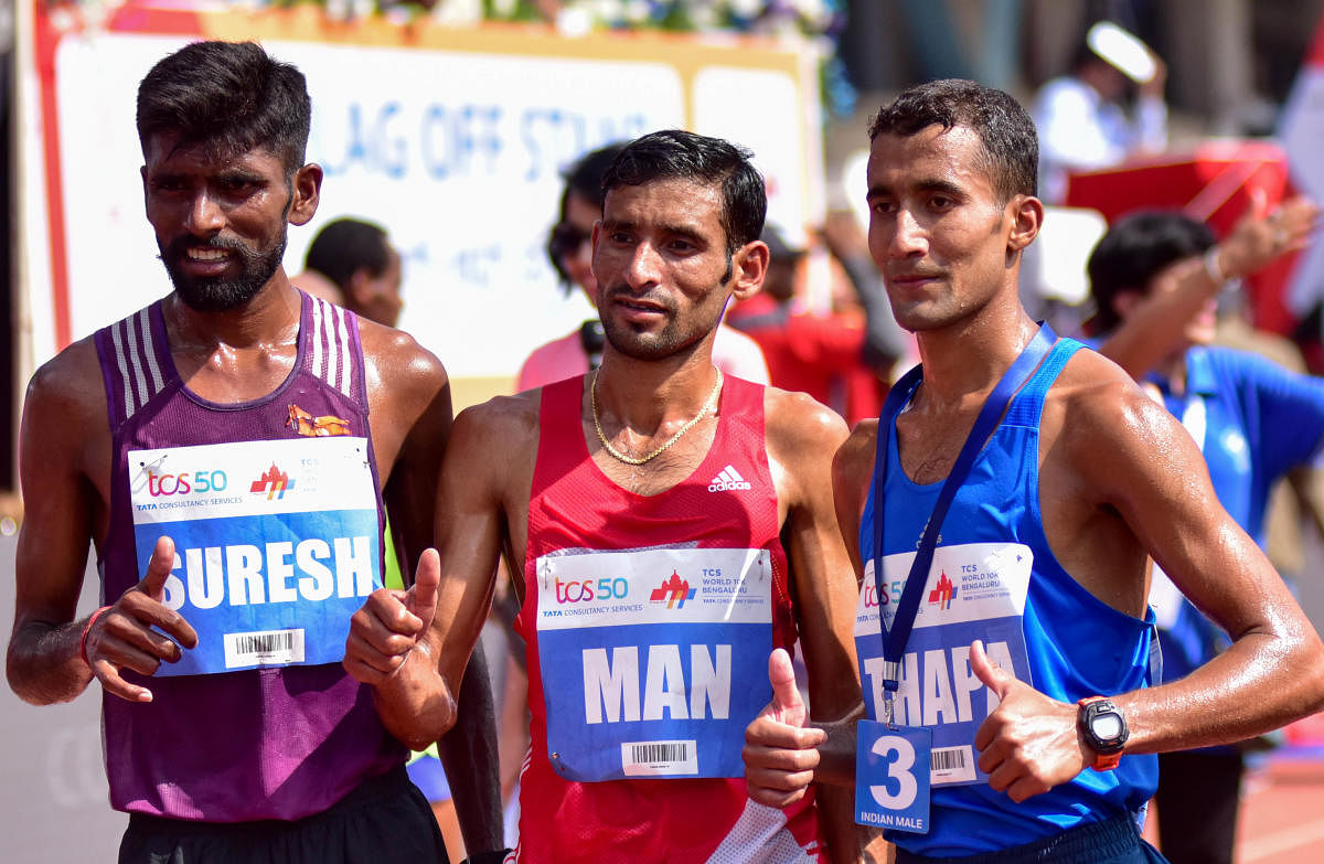 Suresh(Left) winner of the gold in TCS world 10 K run (elite Men INDIA) is seen with the first Runner up Man Singh(Centre) and the second runner up Thapa, at Sree Kanteerava Stadium, in Bengaluru on Sunday.DH Photo