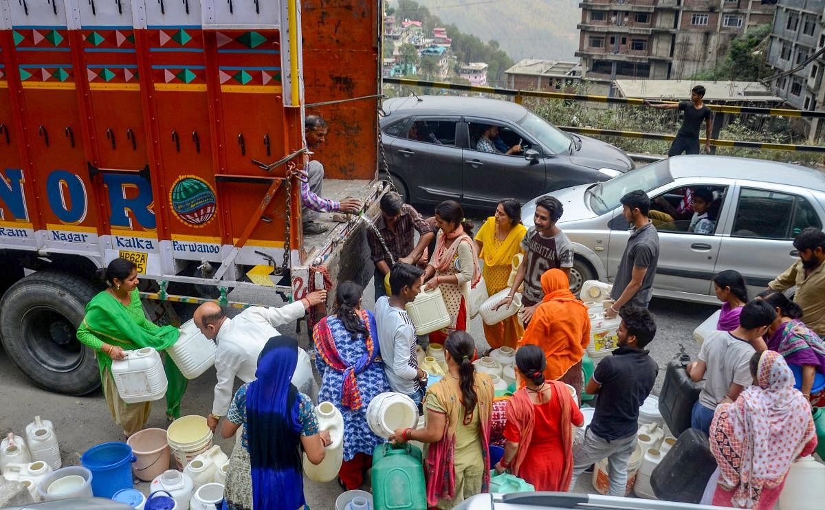 Shimla: People gather around a truck to collect water, as the city faces acute shortage of drinking water, in Shimla on Wednesday, May 30, 2018. (PTI Photo)