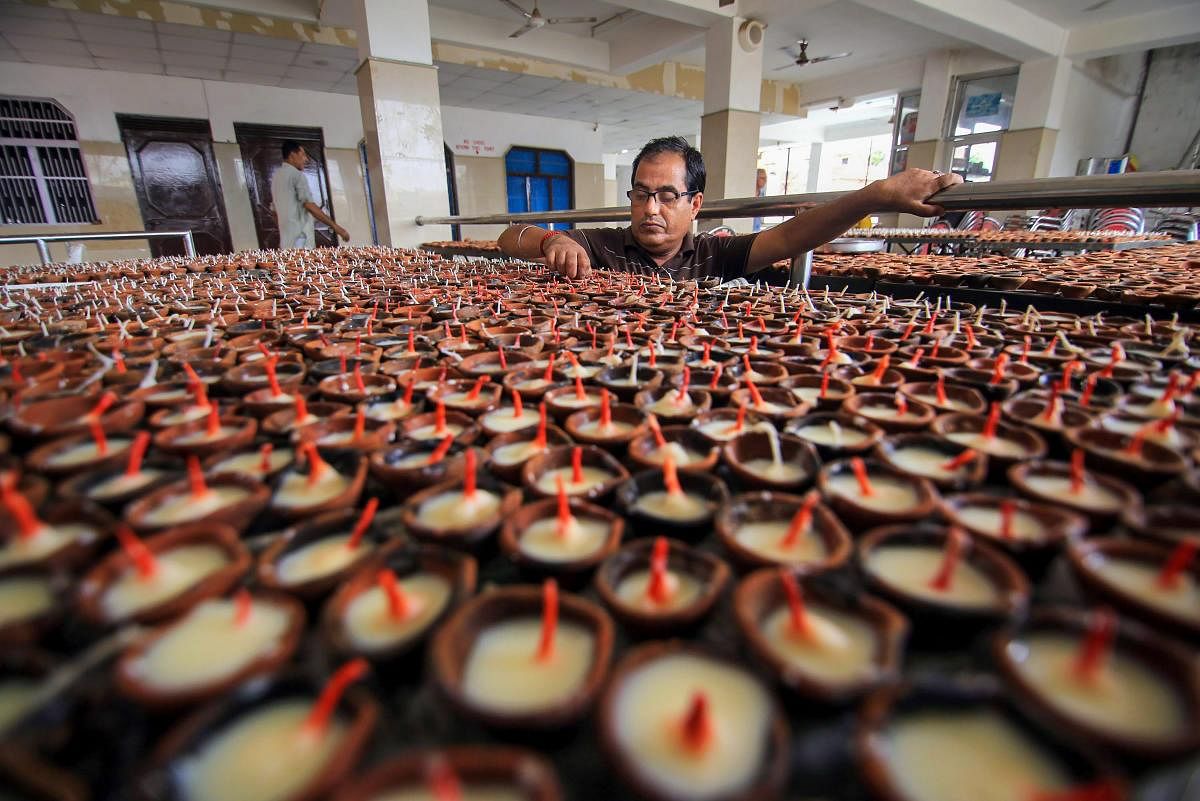 A person from the Kashmiri Pandit community arranges traditional earthern lamps at the replica of Kheer Bhawani temple, during preparations for 'Jyeshthaashtami' annual congregation, in Jammu. PTI Photo
