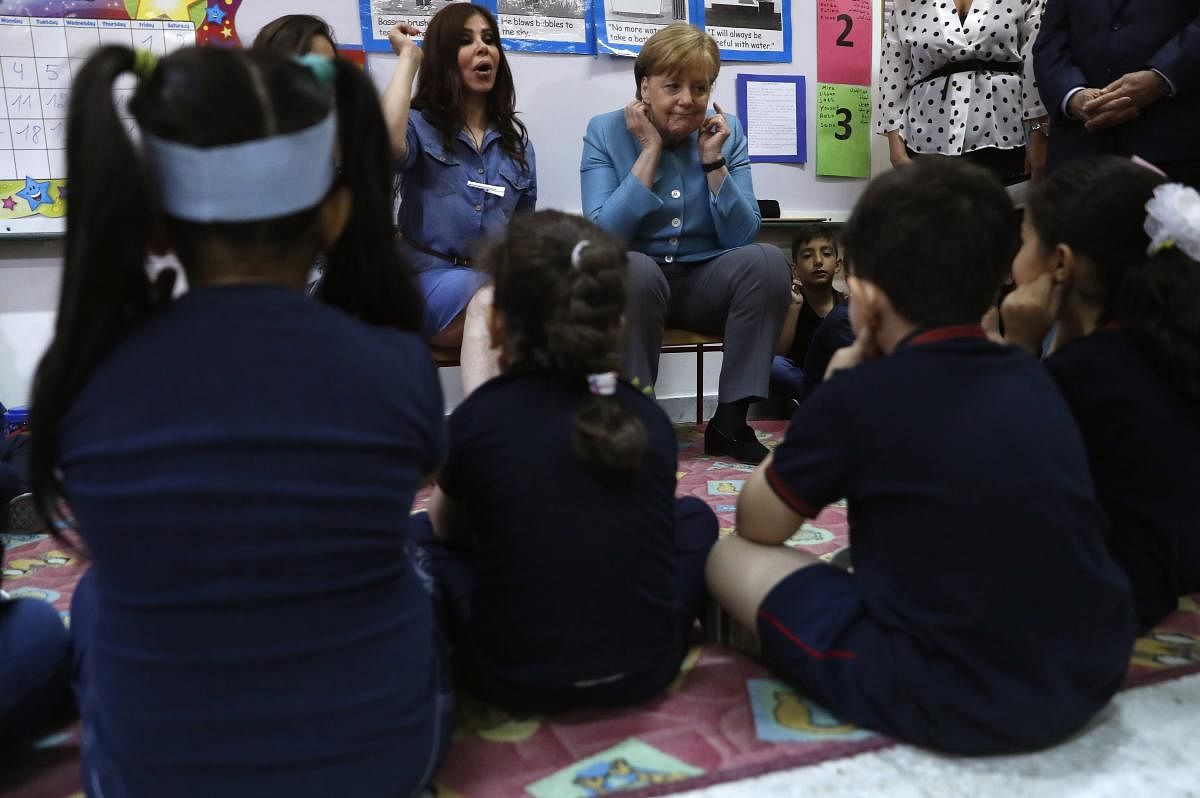 German Chancellor Angela Merkel, center, gestures with Lebanese and Syrian displaced students, during her visit to a Lebanese public school, where both students studying together, in Beirut, Lebanon, Friday, June 22, 2018. Merkel is visiting Jordan and Lebanon, both neighbors of war-torn Syria, amid an escalating domestic row over migration. AP/PTI