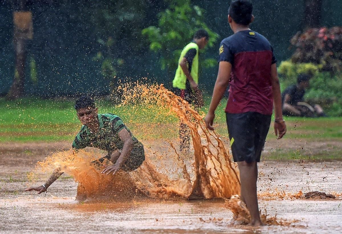 Boys play at a ground during rains, in Mumbai on Sunday, June 24, 2018. PTI