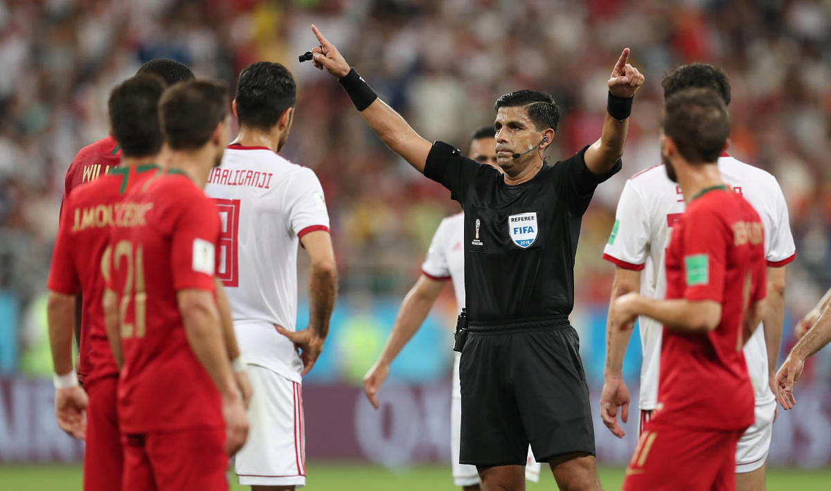 World Cup - Group B - Iran vs Portugal - Mordovia Arena, Saransk, Russia - June 25, 2018 Referee Enrique Caceres reviews a incident on VAR before awarding Iran a penalty. Reuters