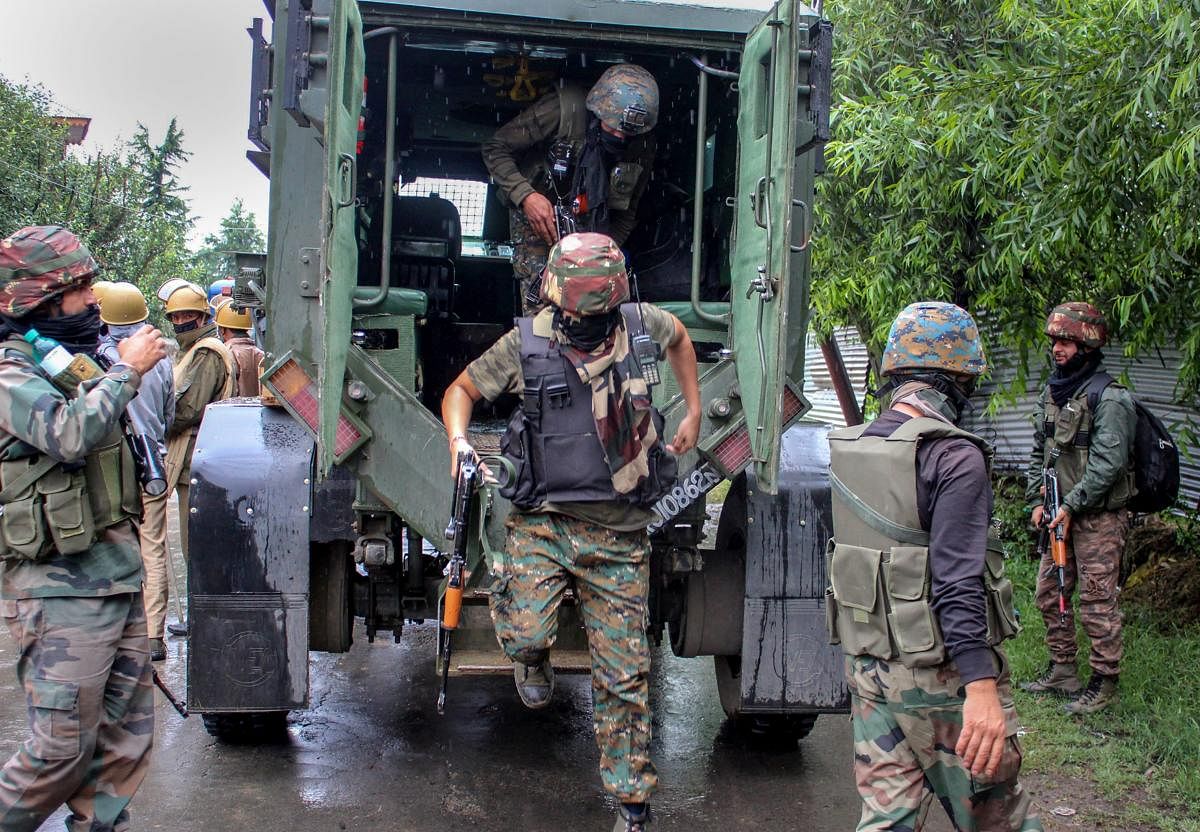 Security personnel outside the house which was held up by alleged militants during an encounter, in Pulwama district of south Kashmir on Friday, June 29, 2018. At least four persons were injured in clashes between stone-pelters and security forces today near an encounter site in Pulwama district where three alleged militants were reportedly trapped. Security forces launched a cordon and search operation in Thumna village after getting information about the presence of militants. (PTI Photo)