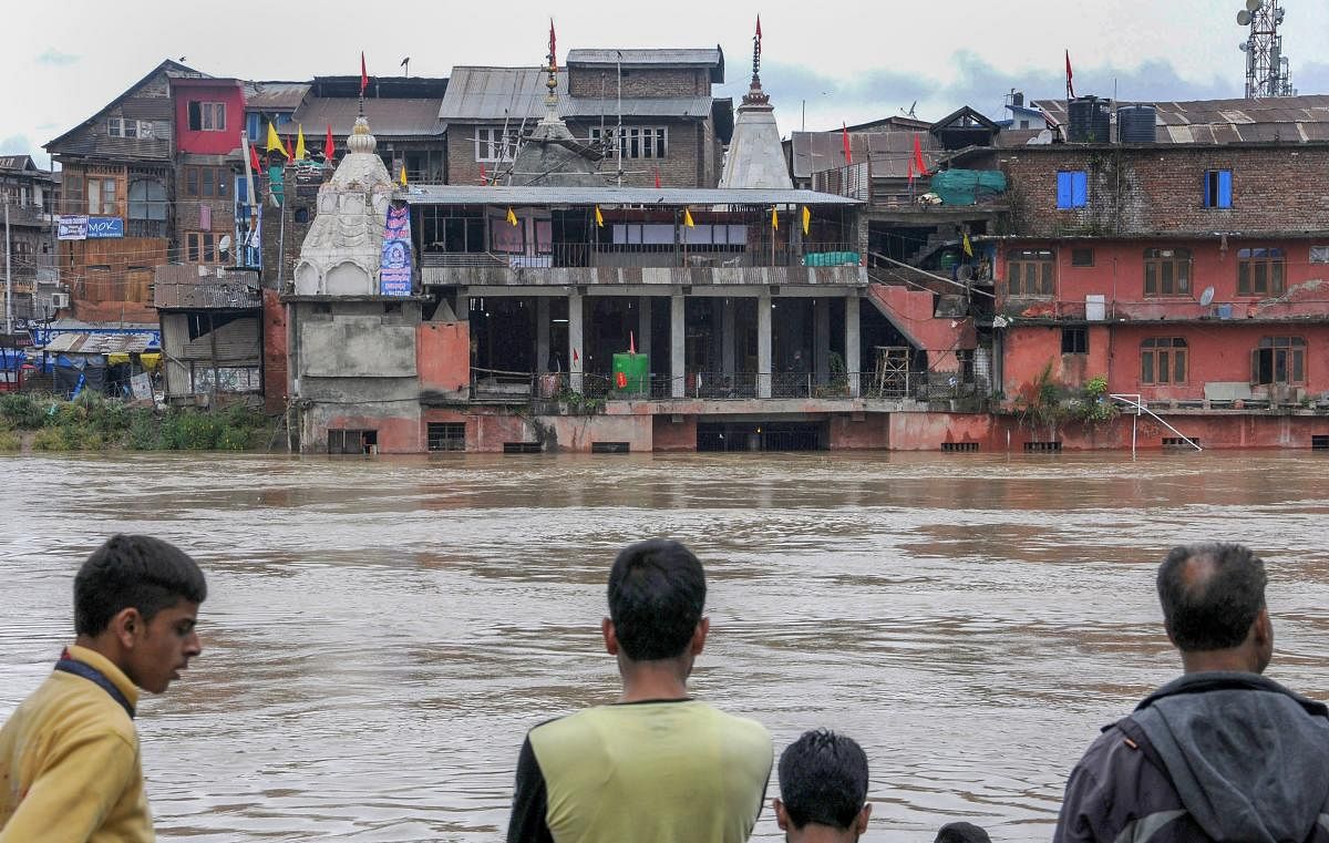 People look at the sumberged Hanumaan Mandir, in Srinagar on Saturday, June 30, 2018. As the rains continue to fall in the Valley, flood alerts have been issued to Srinagar's low lying areas by the authorities. (PTI Photo)