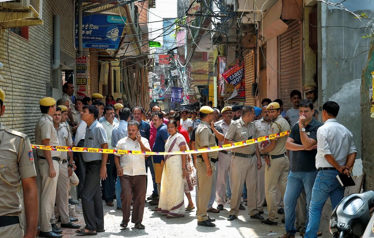 Police presence at the street leading to the crime scene where the four men, three women and four girls were found hanging from an iron grill used as a ventilator in the courtyard of a house in Delhi's Burari on Sunday morning.(PTI Photo)