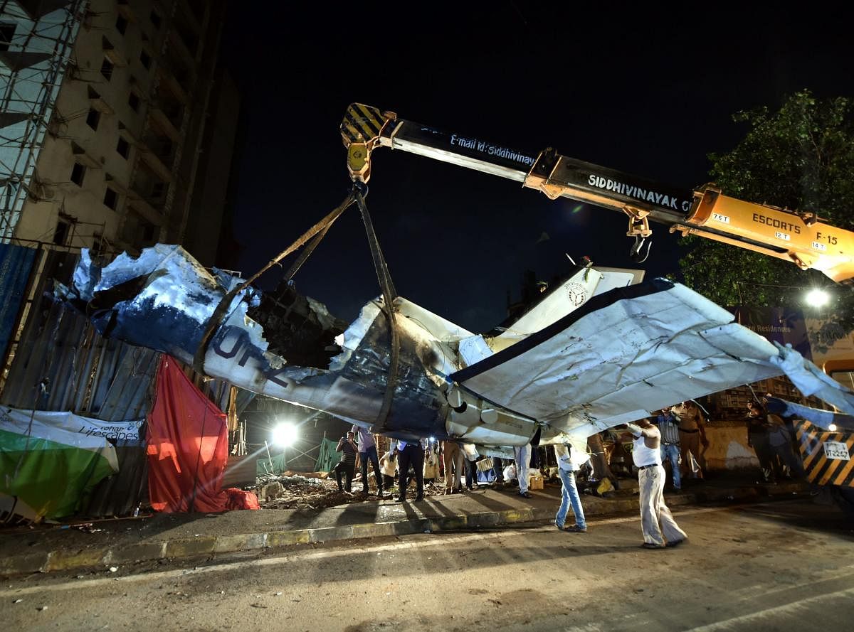 Officials and workers clear the mangled remains of a crashed plane at Ghatkopar in Mumbai on Saturday, June 30, 2018. (PTI Photo)