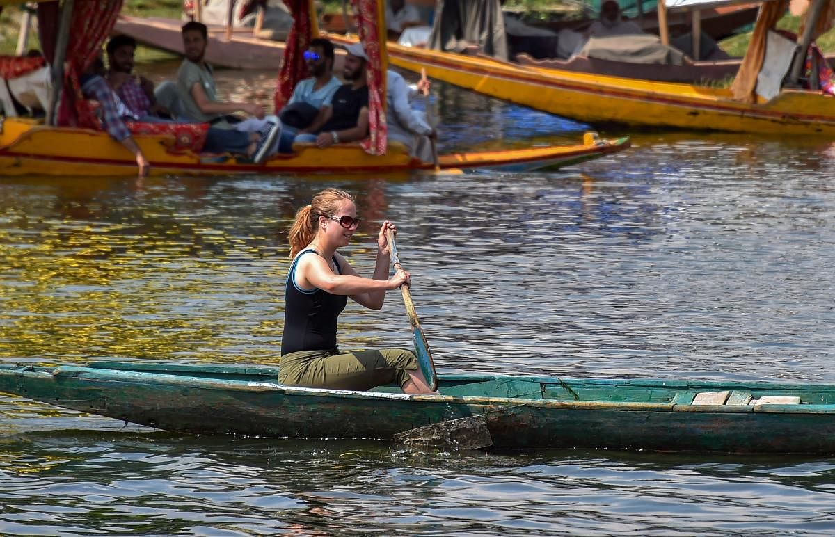 A tourist rows a boat in the waters of Dal Lake, in Srinagar, on Monday, July 02, 2018. (PTI Photo)