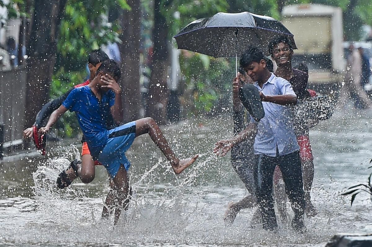 Boys play at a flooded road during rains, in Mumbai on Tuesday, July 3, 2018. (PTI Photo)