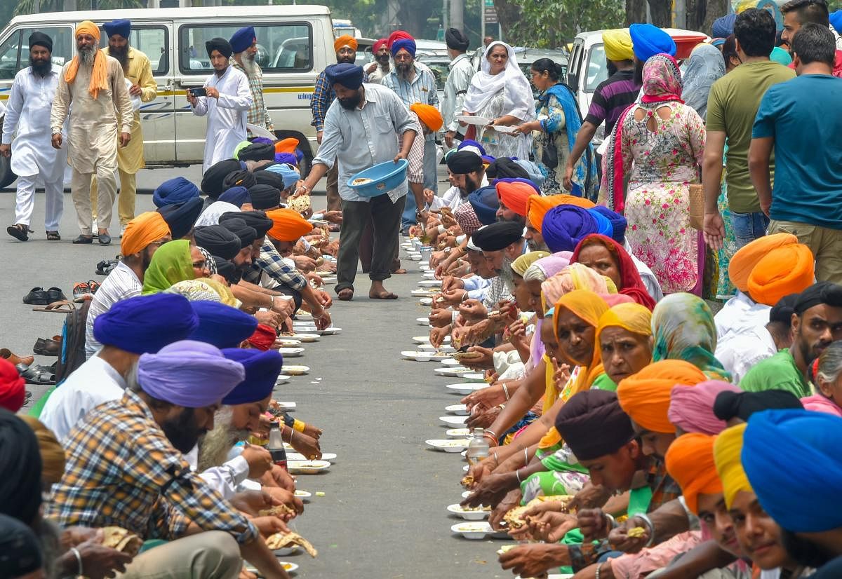Members of Delhi Sikh Gurdwara Management Committee (DSGMC) take 'langar' after their protest against terror attack on Sikh and Hindus in Jalalabad, Afghanistan, in New Delhi on Tuesday, July 3, 2018. (PTI Photo)
