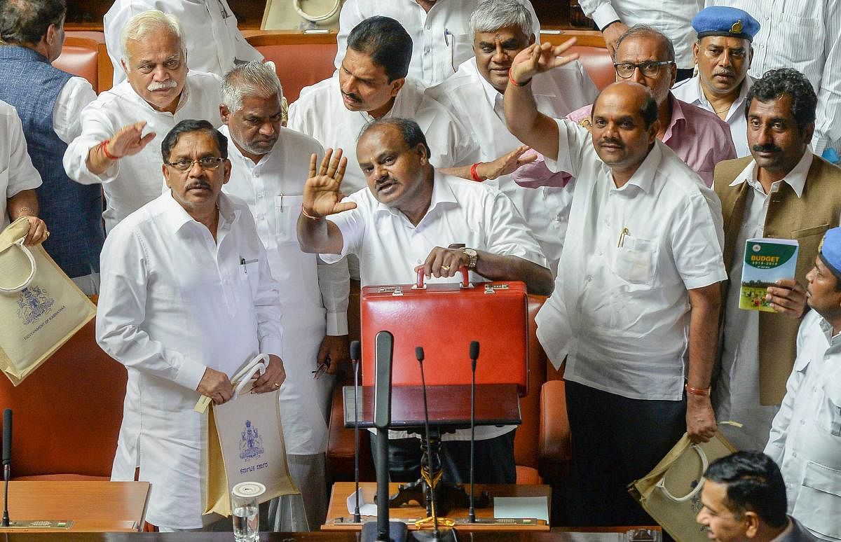 Karnataka Chief Minister HD Kumaraswamy, with his deputy G Parameshwara (L) and other ministers, waves as he leaves after presenting the state budget 2018-19 in the Assembly, in Bengaluru on Thursday, July 5, 2018. (PTI Photo)