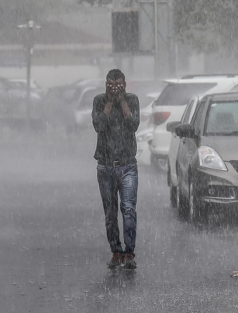 A man, seen drenched, walks at a road during heavy rains, in New Delhi on Thursday, July 5, 2018. (PTI Photo)