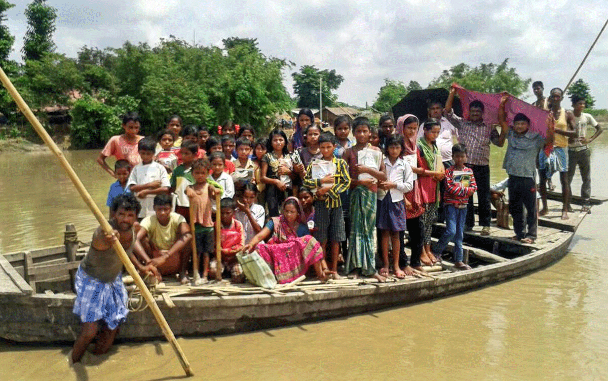 Villagers and schoolchildren board a boat to commute at a village flooded by Menchi River, that was swollen after heavy rains in the hilly areas of neighbouring Nepal, in Kishanganj district of Bihar on Friday, July 6, 2018. (PTI Photo)