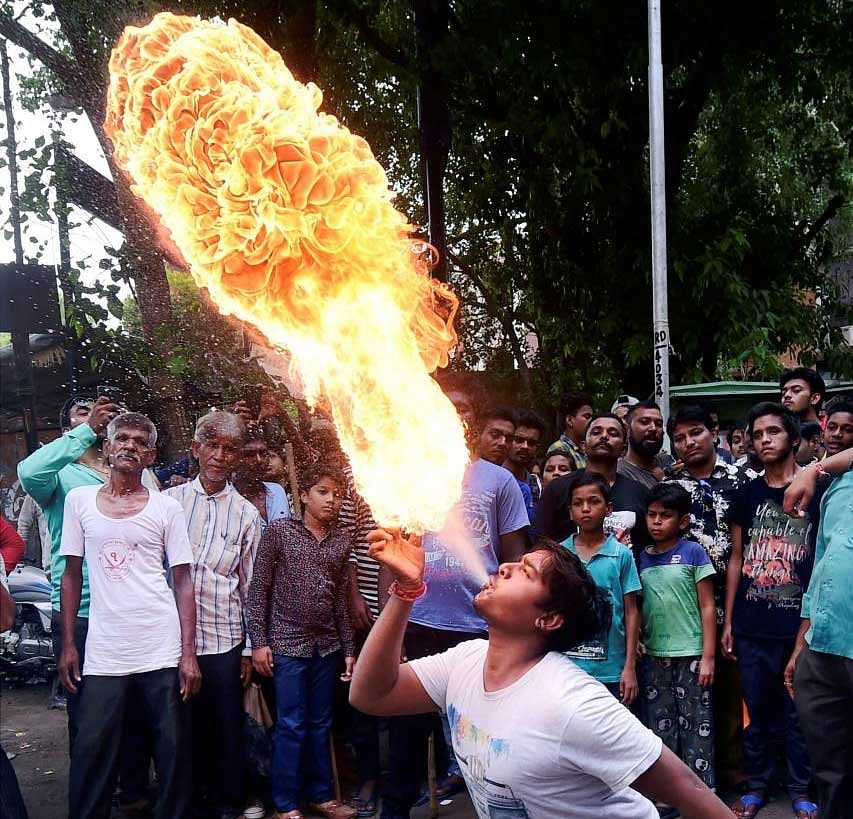 People practice fire stunts ahead of the annual Jagannath Rath Yatra, in Ahmedabad on Sunday, July 08, 2018. PTI Photo