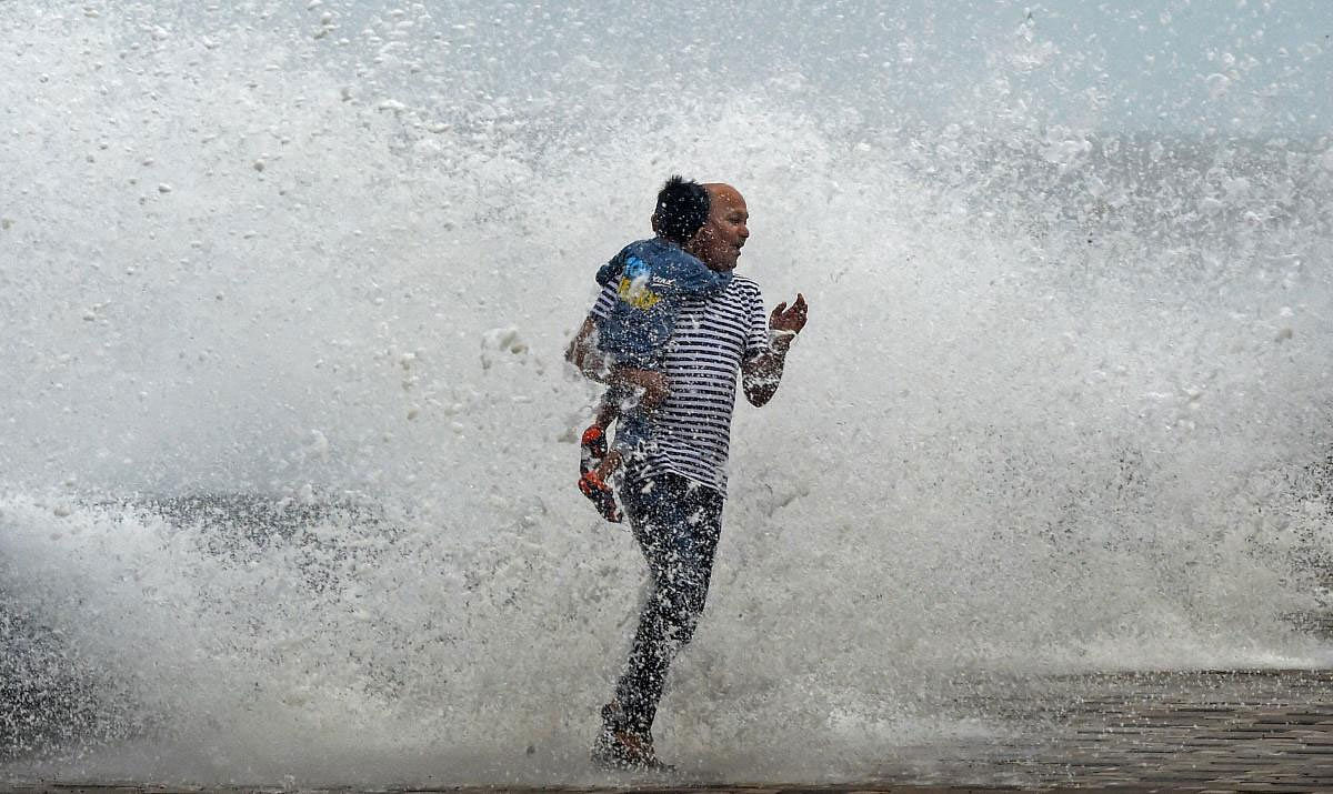 A man reacs during a high tide at the Worli seaface, in Mumbai on Wednesday, July 11, 2018. PTI Photo