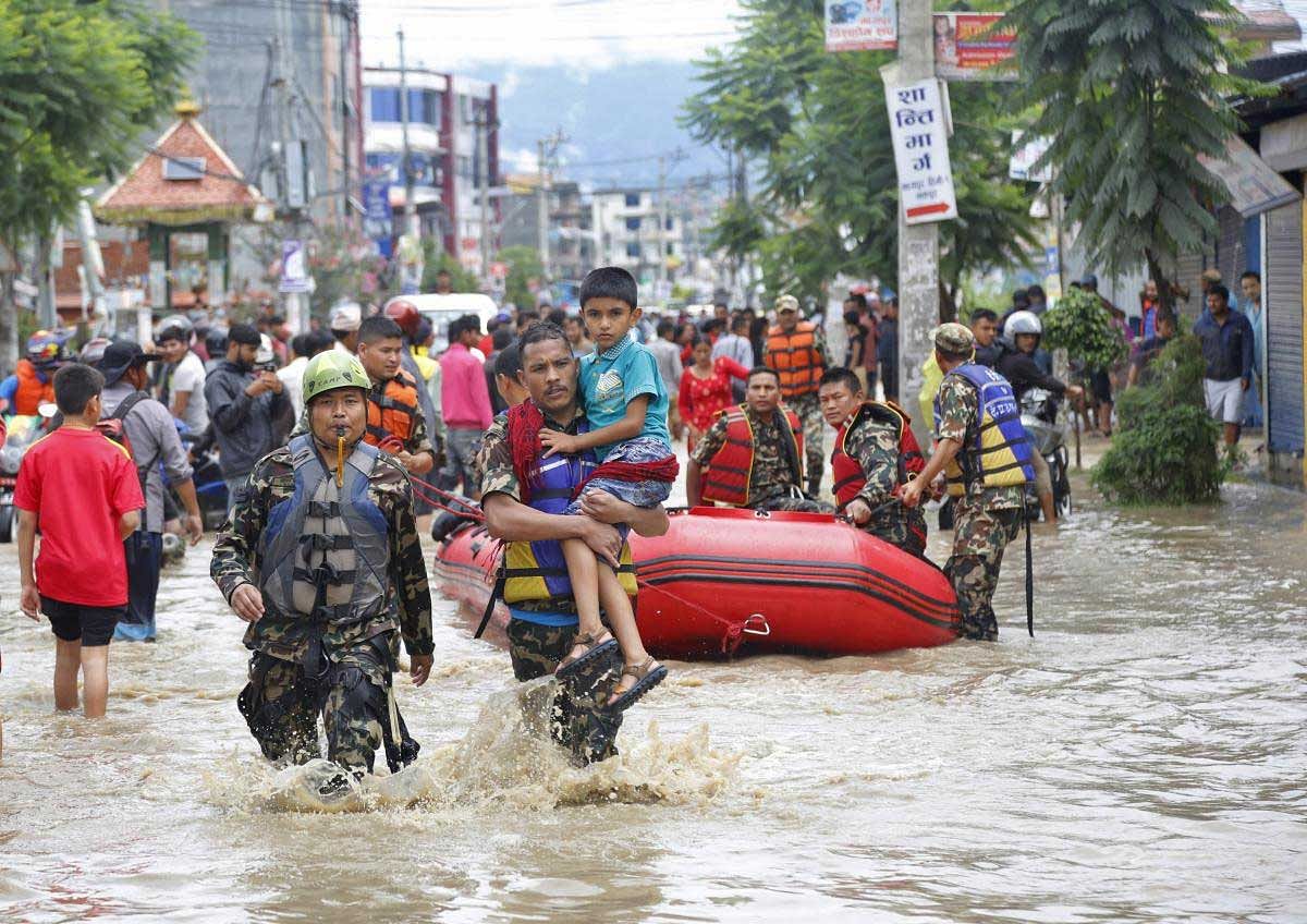 Nepalese army men rescue a sick boy from a flooded area in Bhaktapur, Nepal, Thursday, July 12, 2018. The flooding was caused by overflowing of the Hanumante River following heavy rain Wednesday. AP/PTI