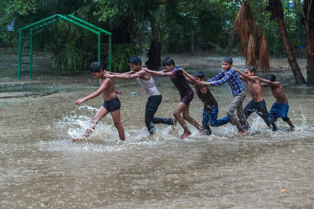 Children play in an open field during heavy rainfall, at Shalimar Bagh in New Delhi on Friday, July 13, 2018. (PTI Photo/Shahbaz Khan)