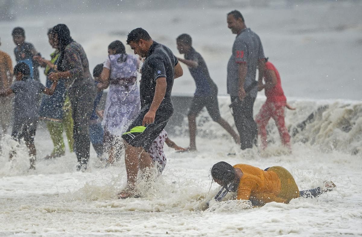 A lady fell down while enjoying a high tide at the Worli sea face in Mumbai on Saturday, July,14, 2018. (PTI Photo/Shashank Parade)