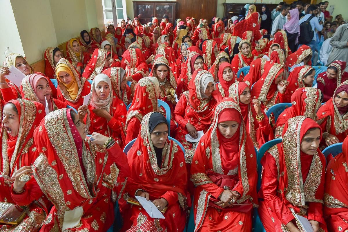 Brides during a mass marriage ceremony, at Amar Singh Club in Srinagar on Sunday, July 15, 2018. In the first ever mass marriage in Kashmir, more than 100 couples tied the knot in a simple function. (PTI Photo/ S. Irfan)