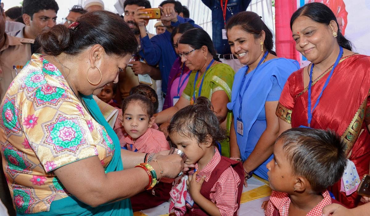 Rajasthan Chief Minister Vasundhara Raje interacts with children as she inaugurates 'Bhamashah Dudh Yojana' at an anganwadi center, in Dungarpur on Monday, July 16, 2018. (PTI Photo)