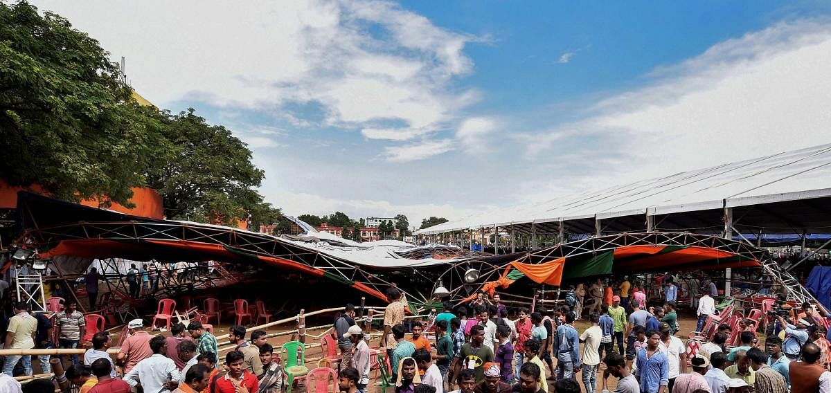 People stand near a tent that collapsed during Prime Minister Narendra Modi's 'Krishi Kalyan Sabha' (public meeting), in Midnapore district of West Bengal on Monday, July 16, 2018. (PTI Photo/Swapan Mahapatra)