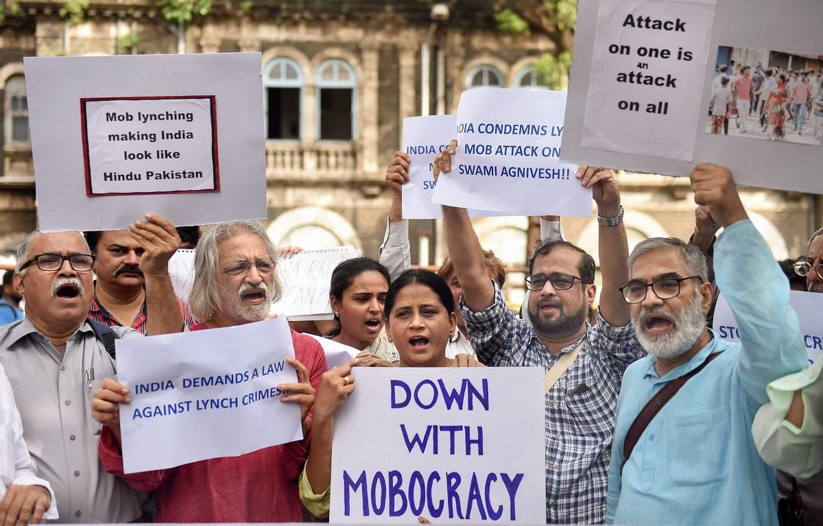 Documentary filmmaker Anand Patwardhan with other activists raise slogans to condemn mob lynching, in Mumbai on Thursday. (PTI Photo/Shashank Parade)